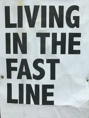 Sign with block letters that says, Living in the fast line