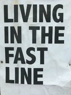 Sign with block letters that says, Living in the fast line